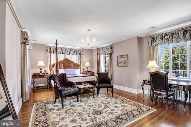 bedroom with an inviting chandelier and dark wood-type flooring