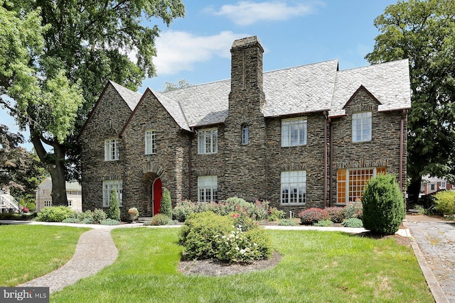 tudor house featuring a front lawn