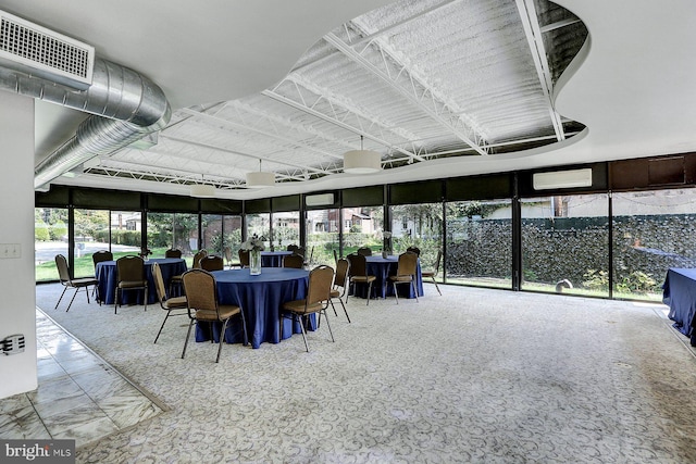 sunroom with a wall mounted air conditioner and a healthy amount of sunlight