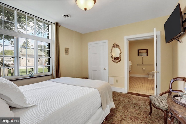 bedroom featuring connected bathroom and wood-type flooring