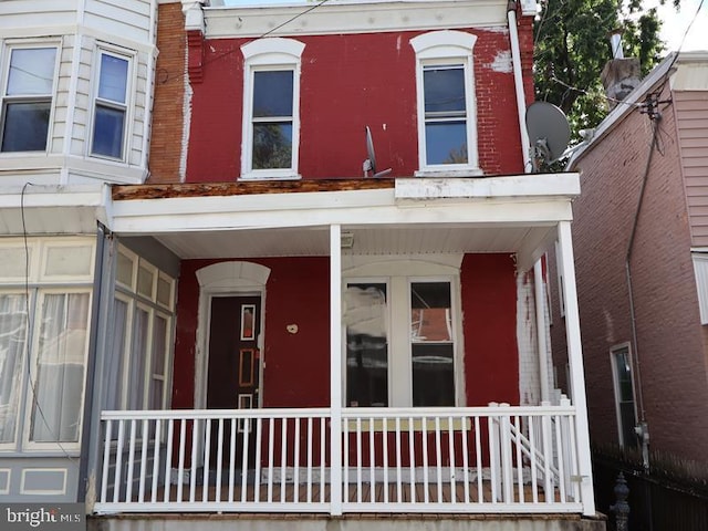 view of front facade featuring covered porch and brick siding