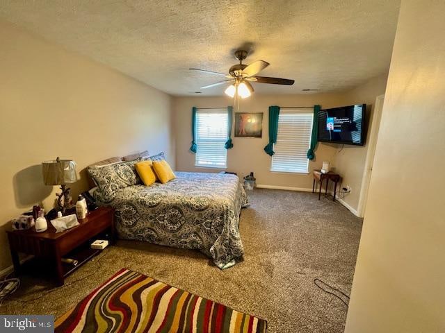 bedroom with ceiling fan, carpet flooring, and a textured ceiling