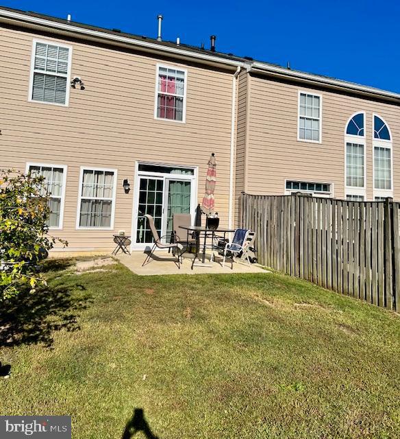 rear view of property with a patio and a yard