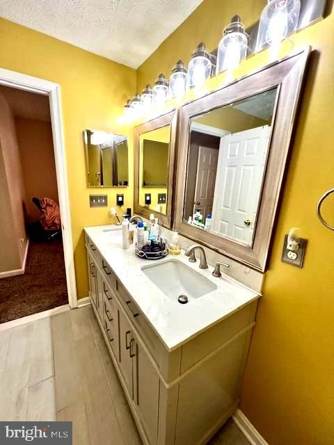 bathroom featuring vanity, tile patterned flooring, and a textured ceiling