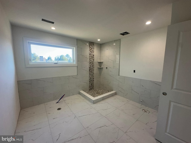 full bathroom featuring marble finish floor, tiled shower, visible vents, and recessed lighting