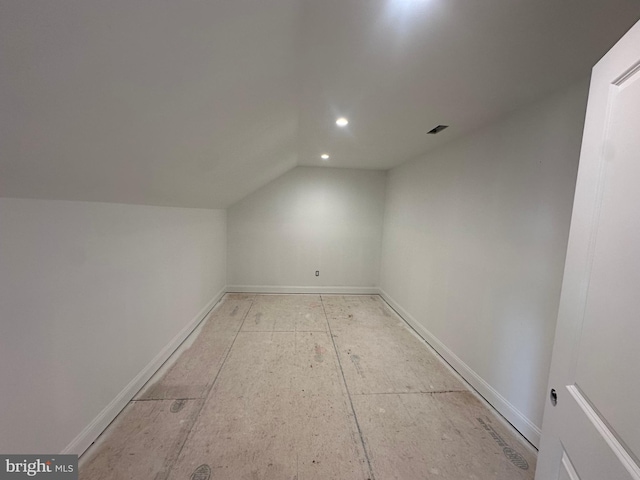 additional living space featuring lofted ceiling, visible vents, baseboards, and recessed lighting