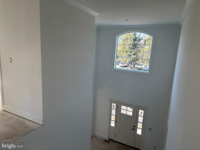 foyer entrance with baseboards, visible vents, and ornamental molding