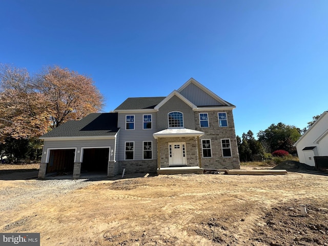 view of front of home with an attached garage, stone siding, and driveway