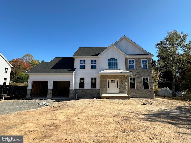 view of front of home with an attached garage, stone siding, and driveway