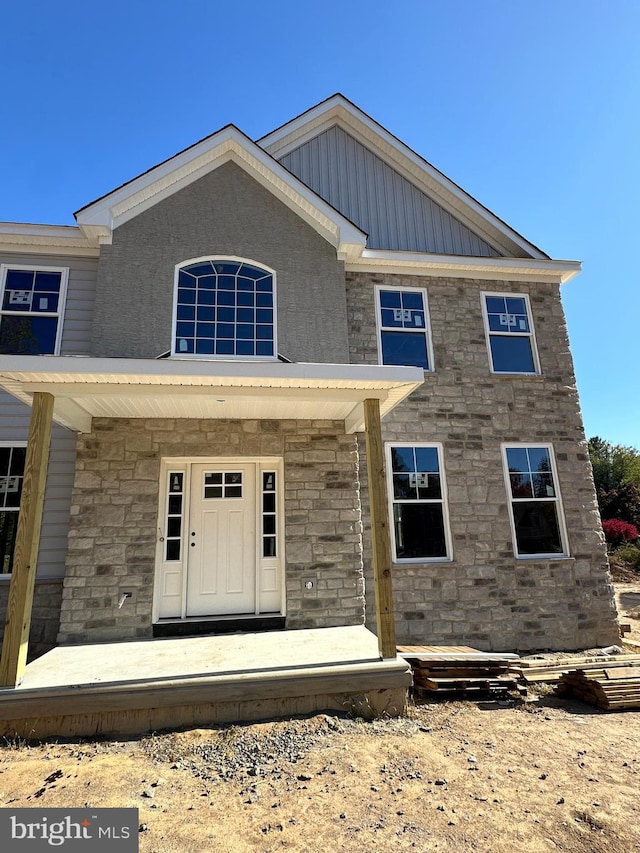 view of front facade featuring stone siding and a porch