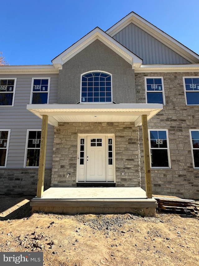 view of front of home featuring stone siding and a porch