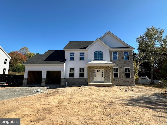 view of front of property with a garage, stone siding, and dirt driveway