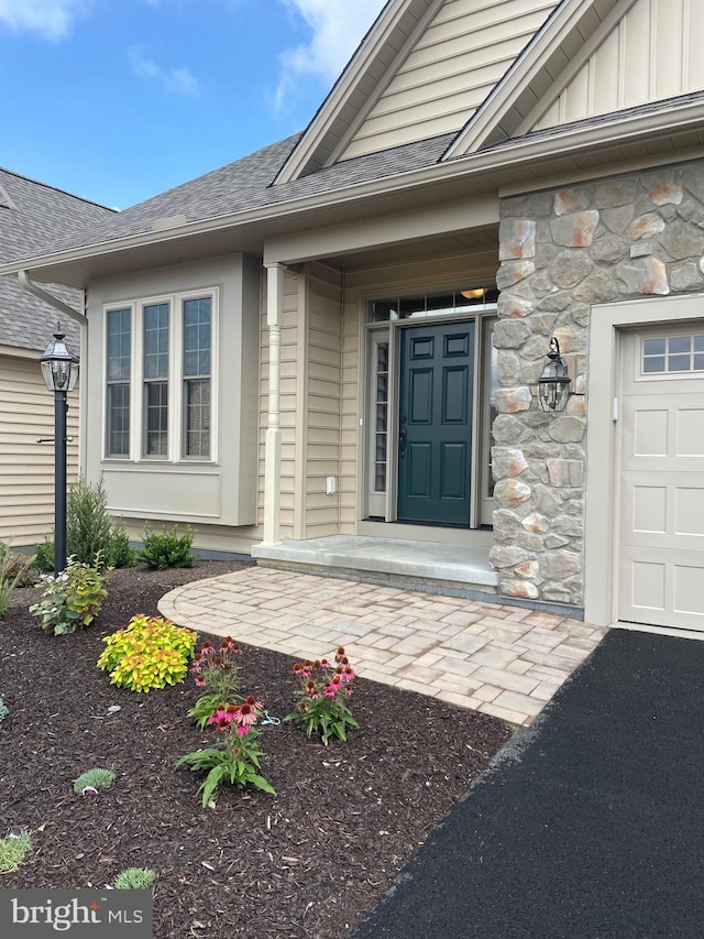 entrance to property featuring covered porch and a garage