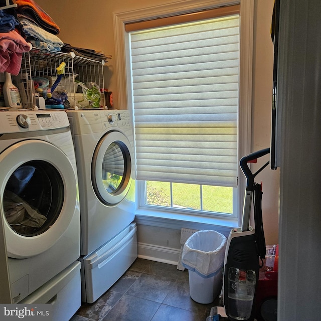 laundry room with dark tile patterned flooring and washer and clothes dryer