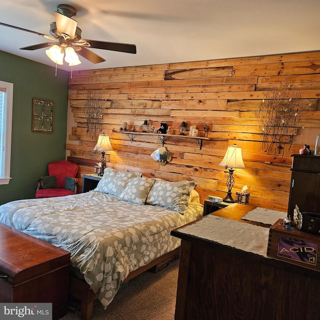 carpeted bedroom featuring wooden walls and ceiling fan