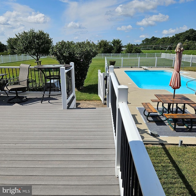 view of pool featuring a lawn and a deck