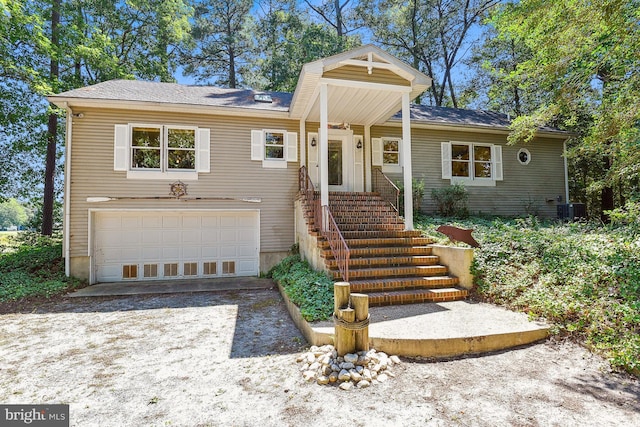 view of front of property featuring central AC, driveway, and an attached garage