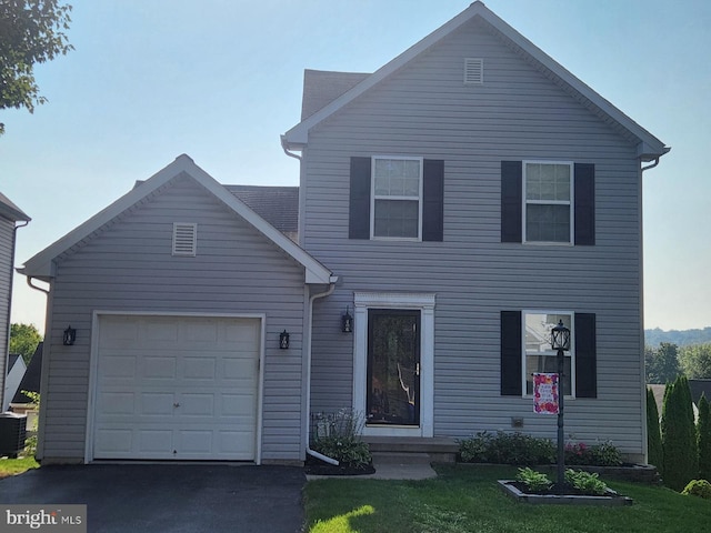 view of front of home with a garage and a front lawn