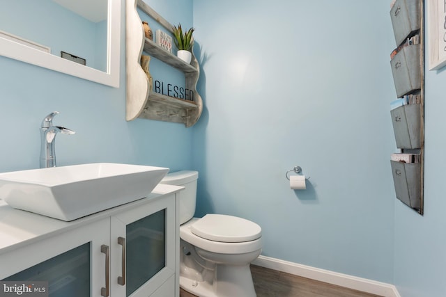 bathroom with vanity, toilet, and hardwood / wood-style flooring