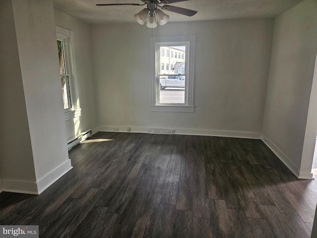 spare room with ceiling fan, a baseboard heating unit, and dark wood-type flooring