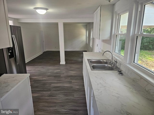 kitchen with dark hardwood / wood-style flooring, white cabinets, sink, and stainless steel fridge