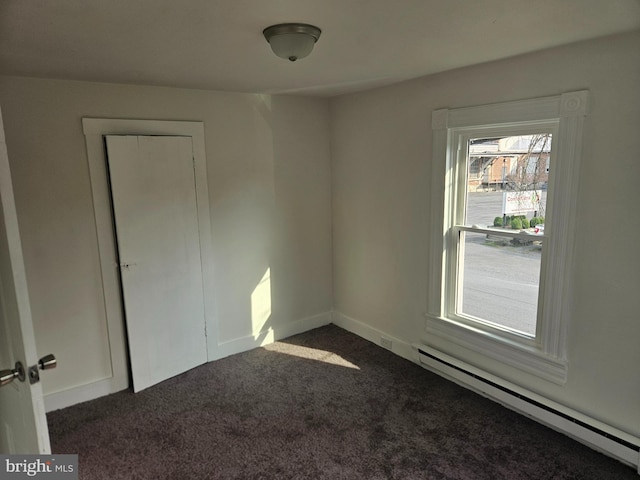 carpeted empty room with baseboard heating