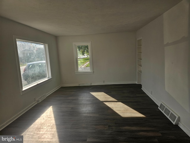 spare room with dark hardwood / wood-style flooring