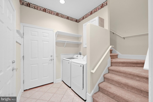 laundry area featuring light tile patterned floors, laundry area, washing machine and clothes dryer, and baseboards