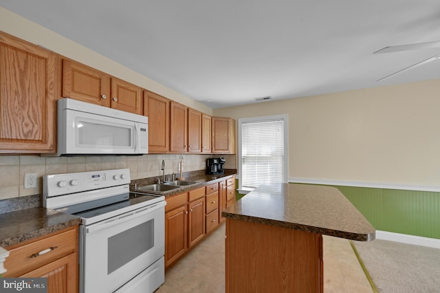 kitchen with ceiling fan, backsplash, a kitchen island, sink, and white appliances