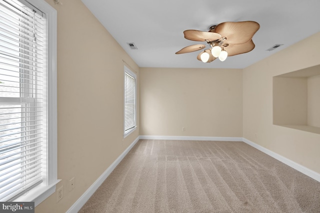 unfurnished room featuring ceiling fan, carpet floors, visible vents, and baseboards