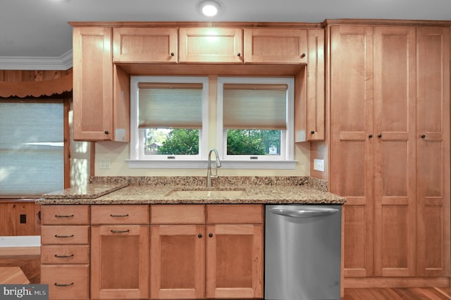 kitchen with stainless steel dishwasher, sink, crown molding, light stone countertops, and hardwood / wood-style flooring