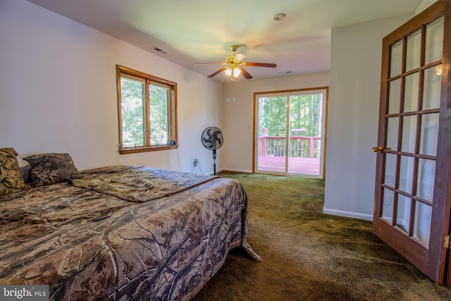 carpeted bedroom with access to exterior, visible vents, multiple windows, and baseboards