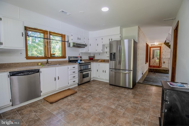 kitchen with visible vents, under cabinet range hood, a sink, appliances with stainless steel finishes, and white cabinets