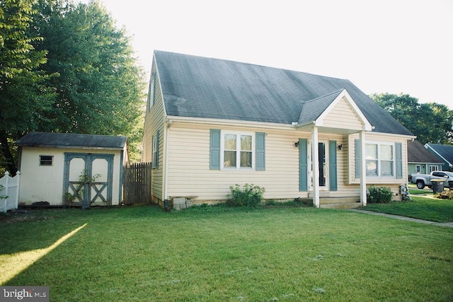 view of front of home with a storage shed and a front lawn