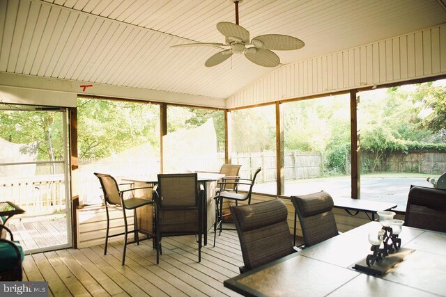 sunroom / solarium featuring a wealth of natural light, ceiling fan, and lofted ceiling