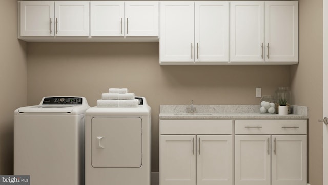 laundry room with washer and dryer, sink, and cabinets