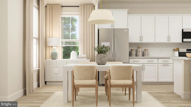 kitchen featuring tasteful backsplash, stainless steel fridge, white cabinets, and pendant lighting