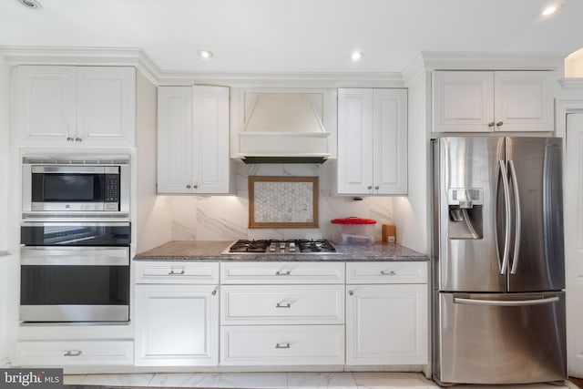 kitchen with white cabinets, backsplash, custom range hood, appliances with stainless steel finishes, and light tile patterned flooring