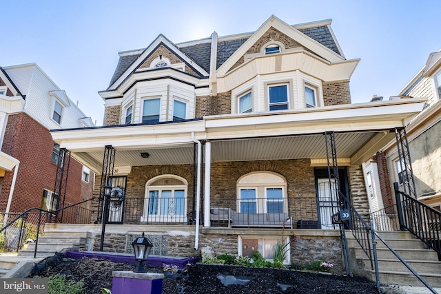 view of front facade featuring brick siding and a porch