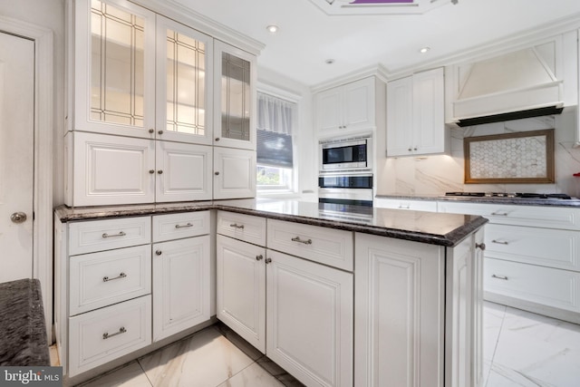 kitchen with premium range hood, stainless steel appliances, white cabinets, marble finish floor, and tasteful backsplash