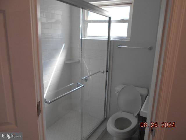 bathroom featuring a shower stall and toilet