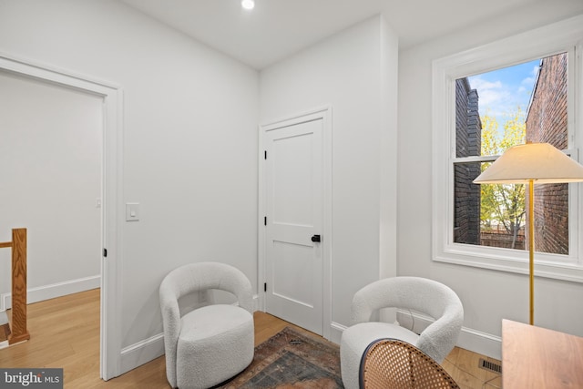 sitting room with a healthy amount of sunlight and hardwood / wood-style flooring