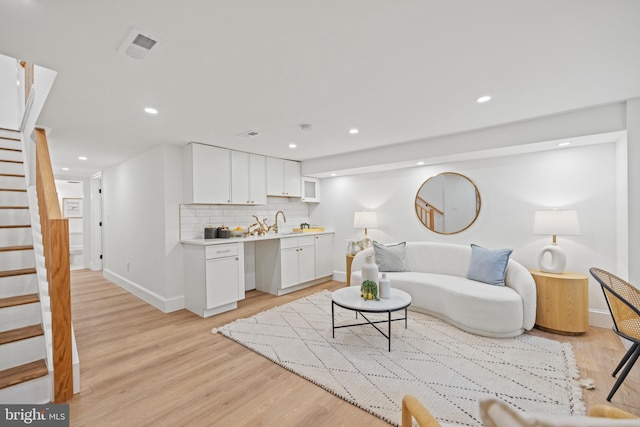 living room with light hardwood / wood-style flooring and sink