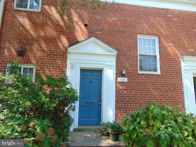 doorway to property with brick siding