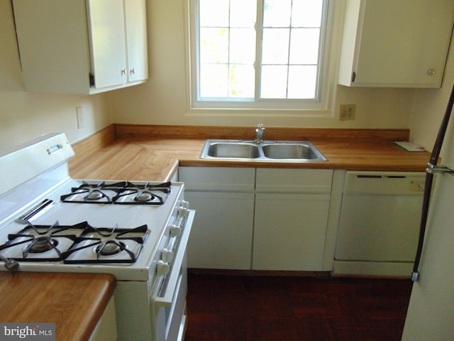 kitchen with white appliances, white cabinetry, and a sink