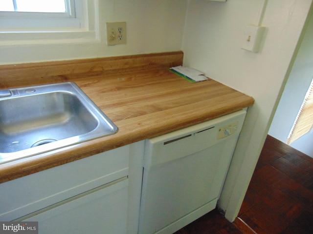 room details featuring white cabinets, dishwasher, sink, and wood counters