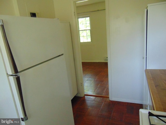 kitchen with baseboards and freestanding refrigerator