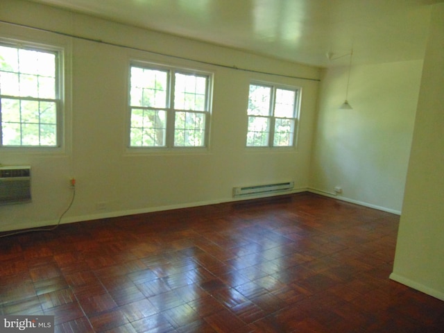 unfurnished room featuring a baseboard radiator and a healthy amount of sunlight