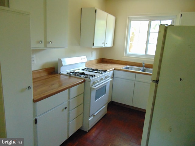 kitchen with white appliances, dark hardwood / wood-style floors, white cabinetry, and sink