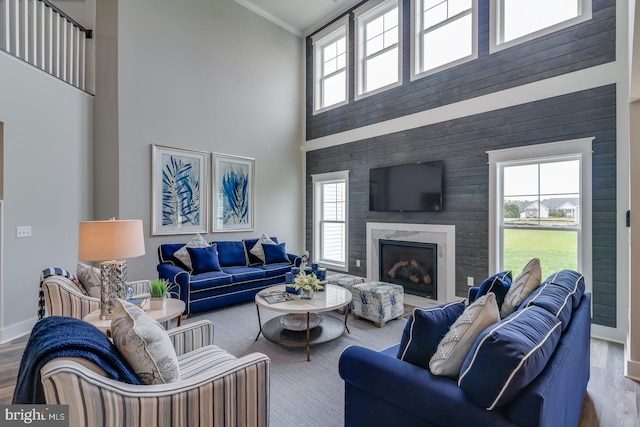 living room featuring a fireplace, a towering ceiling, and a wealth of natural light